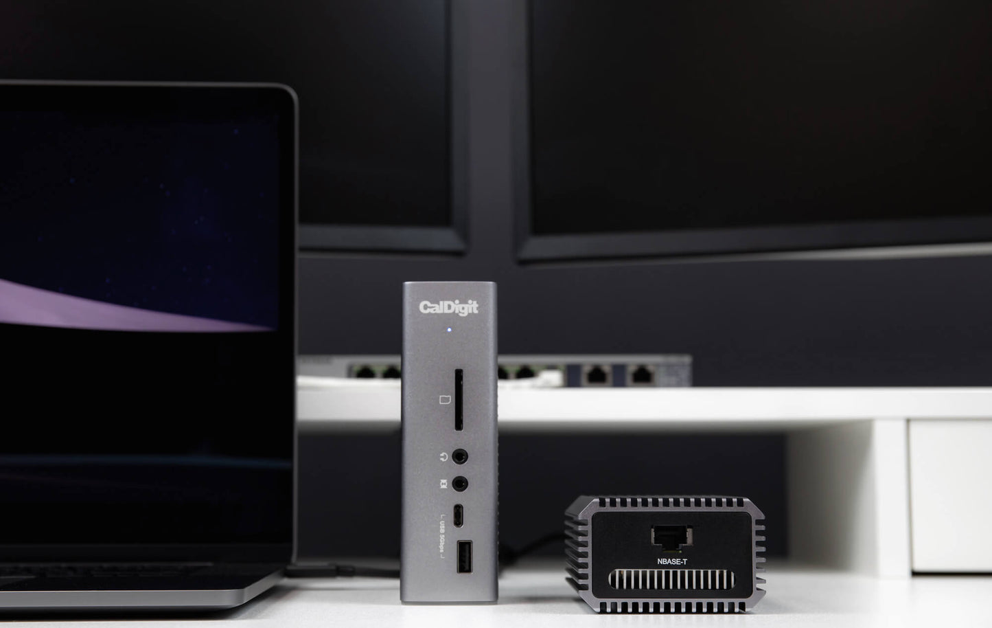 A Connect-10G on a desk next to a Thunderbolt dock and a laptop.